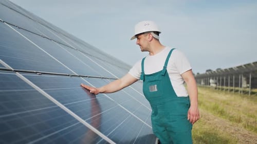 Engineer Inspecting Solar Panels in a Rural Field