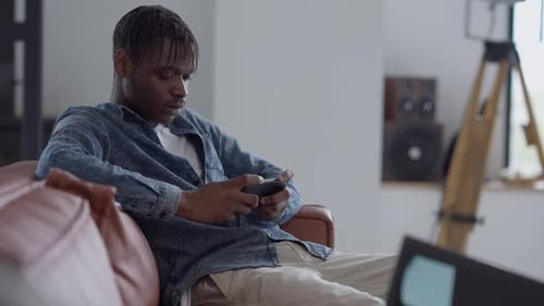 Young Adult Using Mobile Device on Couch