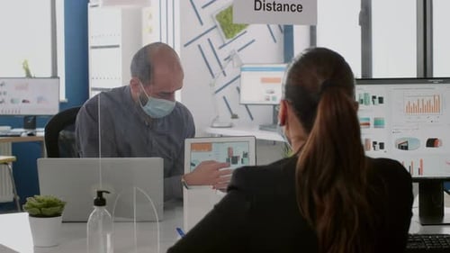 Masked Workers at Desks with Plexiglass Divider