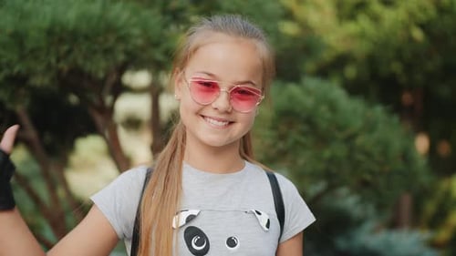 Girl Smiling and Giving Thumbs Up Outside
