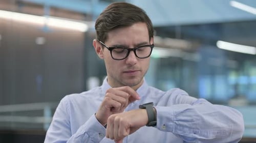Man in Glasses Using Smart Watch Indoors