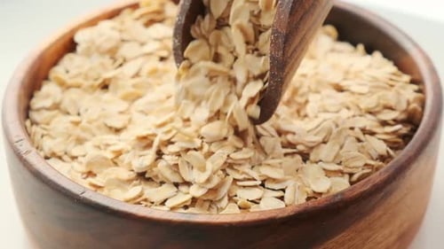 Rolled Oats Poured into Wooden Bowl
