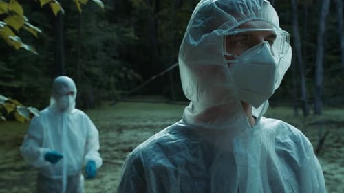 Scientists in Protective Suits Working in Forest
