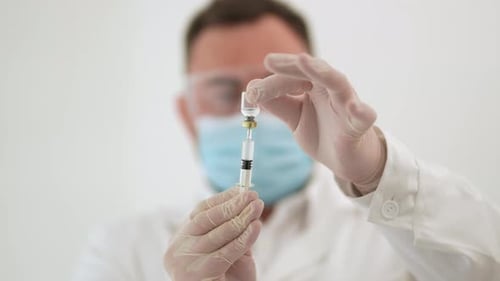 Medical Professional Drawing Vaccine into Syringe