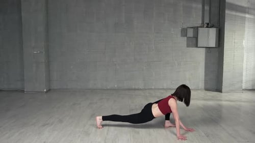 Young Woman Does Yoga Stretch in Gray Room