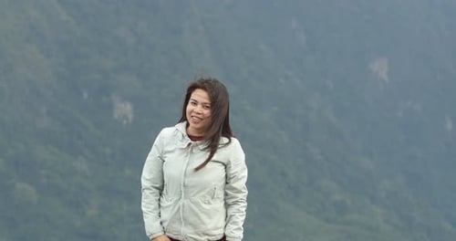 Frau feiert auf dem Gipfel des Berges