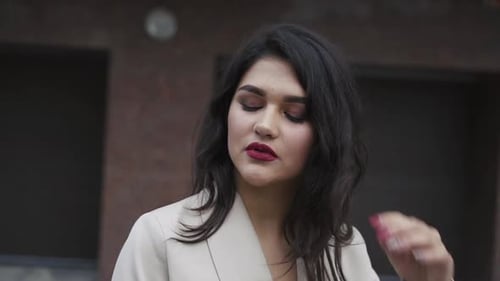 Woman with Dark Hair in Cream Suit