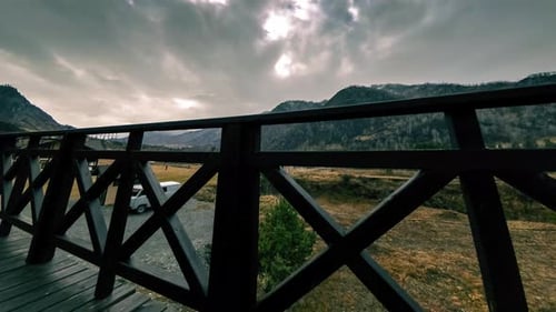 Timelapse of Wooden Fence on High Terrace at Mountain Landscape with Clouds. Horizontal Slider