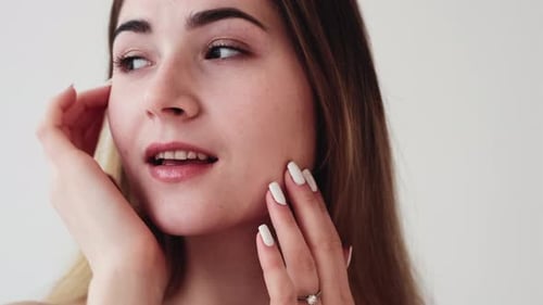 Cuidado facial hidratante de la piel Mujer tocando la cara