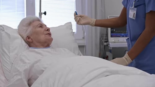 Senior Female Patient Talking with Nurse during Procedure