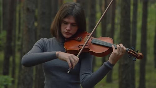 Woman Plays Violin in a Peaceful Forest