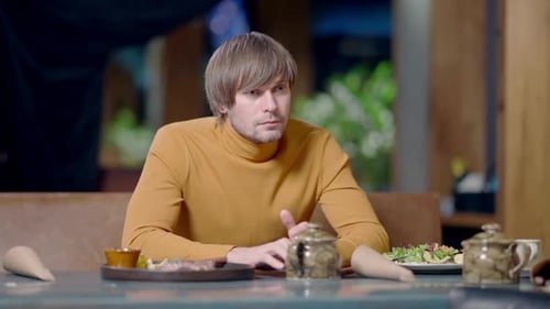 Anxious Young Handsome Man Sitting in Restaurant Waiting for a Date