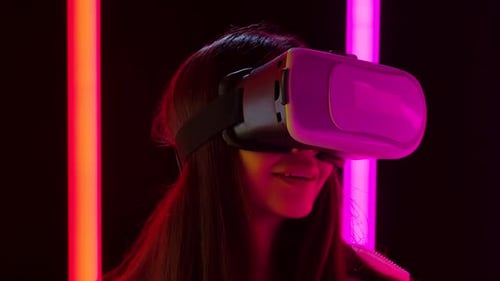 Woman Experiencing Virtual Reality With Neon Lights