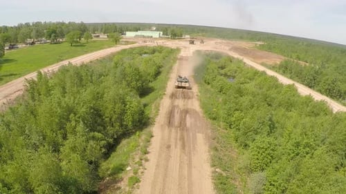 Auf unebenem Boden des Trainingsgeländes über den Panzer fliegen