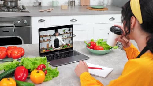 Woman follows online cooking class on laptop