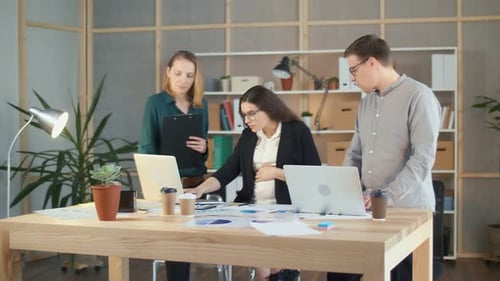 Une femme d'affaires enceinte prospère travaille avec des collègues