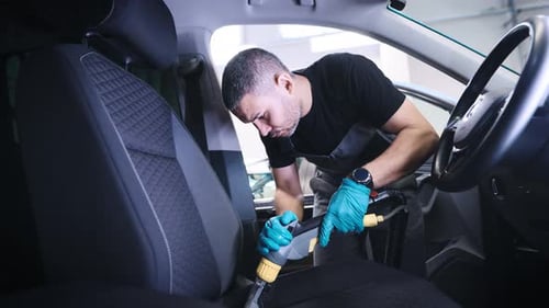 Auto Detailer Cleaning Car Interior Seats