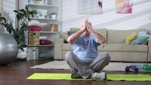 Senior Man Practices Yoga at Home