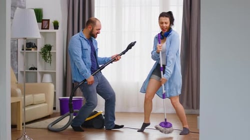 Couple Pretending to Play Music with Cleaning Tools
