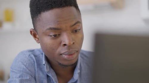 Headshot of Tired Young Handsome Man Rubbing Eyes in Slow Motion Sitting with Laptop in Home Office