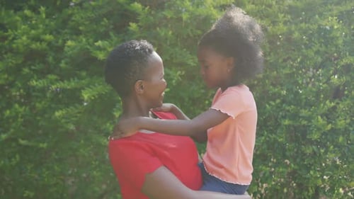 Loving Woman and Child Together Outside in Sunlight