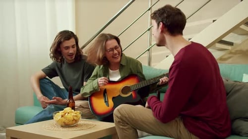 Friends Playing Guitar and Relaxing Together Indoors