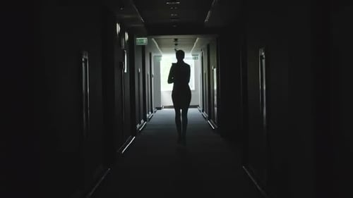 Silhouette Walking Down Dark Hallway to Light