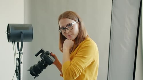 Slow Motion of Photographer Taking Pictures in Studio Talking Looking at Camera