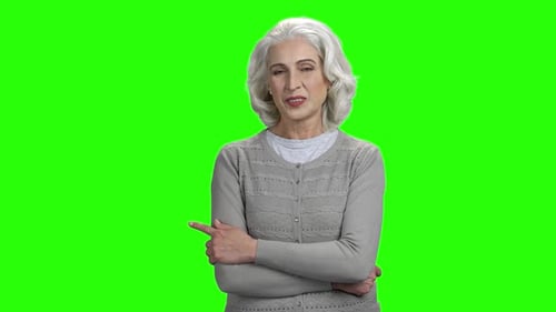 Senior Woman Pointing on Green Screen Background