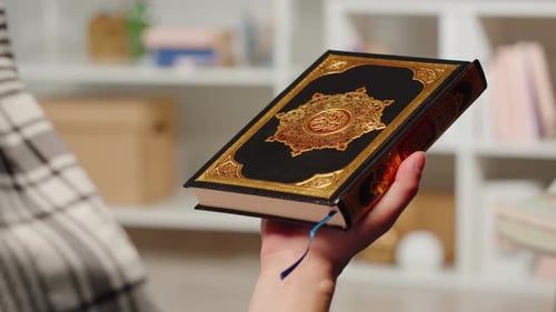 Hand Holding Black and Gold Decorated Book
