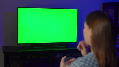 Woman Watching Chroma Key Television at Night Indoors