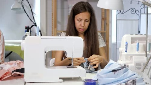 Seamstress at Work in Workshop Sewing Clothes on Sewing Machine