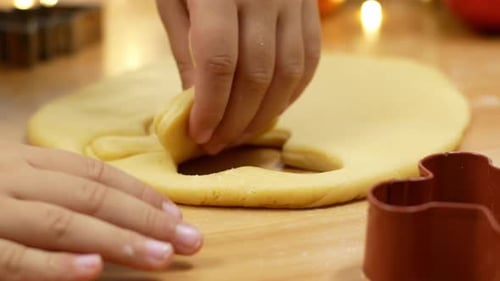 Child Making Christmas Cookies with Cookie Cutters