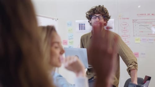 Energetic Man Presents with Laptop in Modern Office