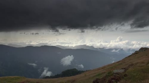 Schwarze dunkle Gewitterwolken in bergigem Terrain