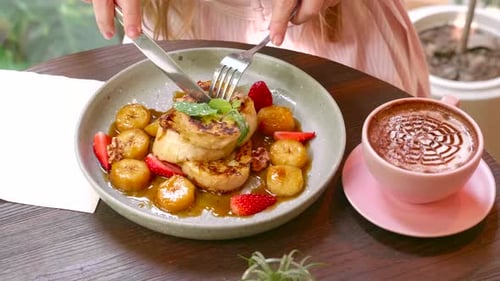 Woman Hands Cuts a Stack of French Toasted Bread in Caramel Syrup with Berries