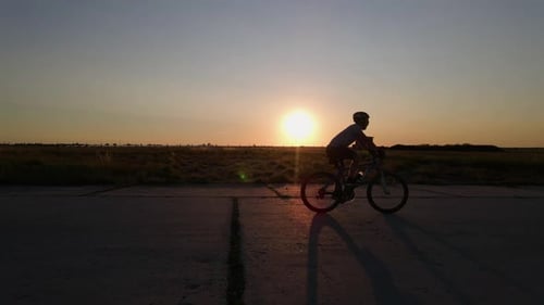 Silhouette eines Mountainbikers bei Sonnenuntergang, Zeitlupe