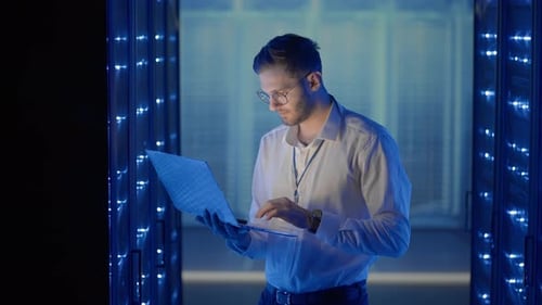 Man Working on Laptop in Futuristic Server Room