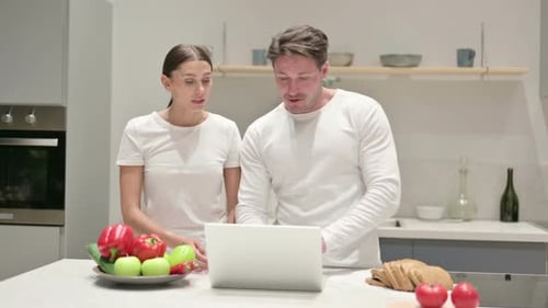 Couple Using Laptop in Modern Kitchen