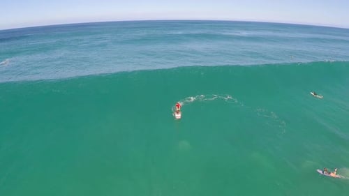 Aerial view of a man sup stand-up paddleboard surfing in Hawaii