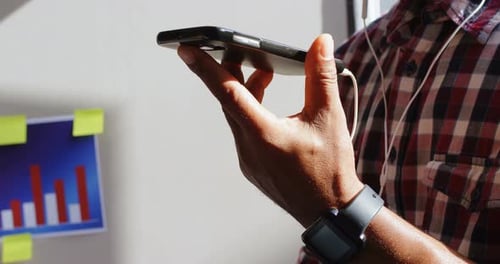 Man Using Smartphone with Headphones in Office