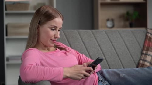 Woman Relaxing at Home Using Smartphone