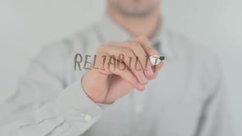 Man Writes Reliability on Clear Surface