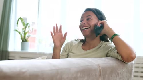 Woman Chatting Happily on Phone Indoors at Home