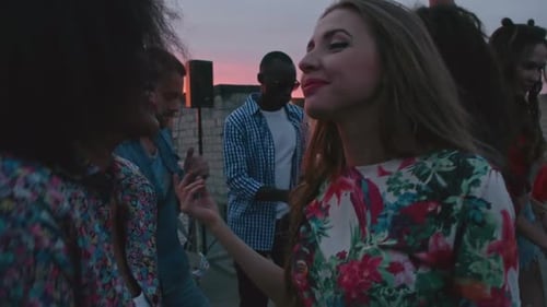 Young Adults Dancing on Rooftop at Sunset