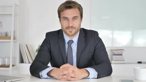 Business Man Sitting at Desk in Office Environment