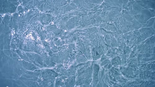 Zeitlupenwasser kräuselt sich vor blauem Hintergrund