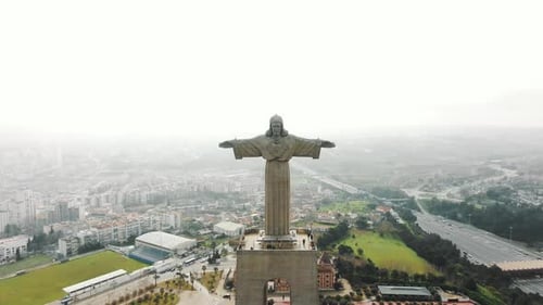 Majestic Jesus Monument Against White Cloudy Sky and Lisbon