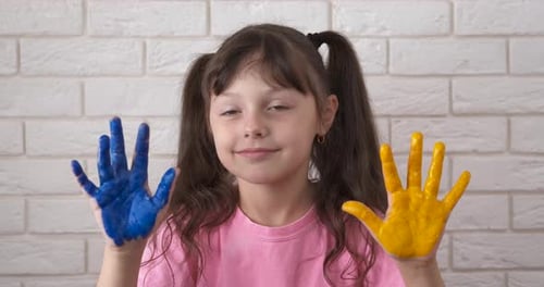 Happy Girl with Colorful Painted Hands Smiling