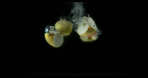 Apples, malus domestica, Fruit entering Water against Black Background, Slow Motion 4K